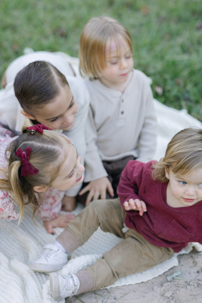 four young kids snuggled in close during their family session in east texas