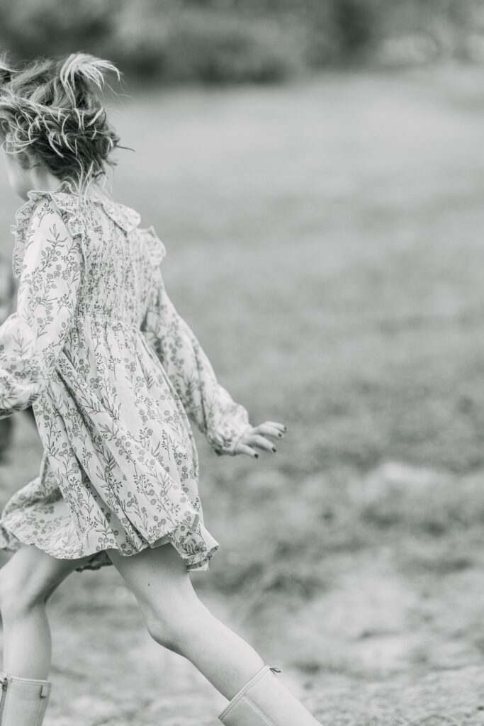 young daughter running by the camera playfully during a family session in east texas
