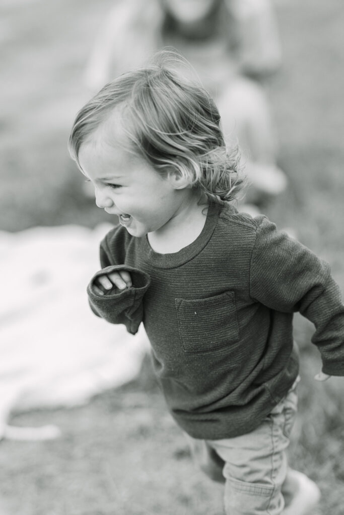 young toddler running across the frame of the camera playfully during the family fall photo session
