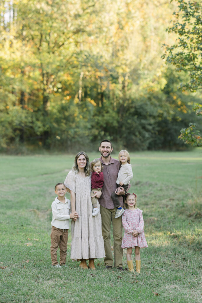 East Texas family standing in an open field at sunset